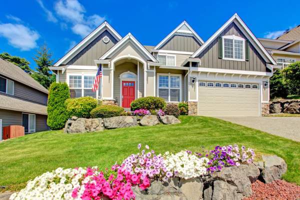 gray-house-with-red-door-yard-and-flowers