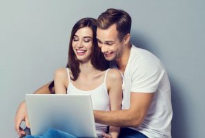 young-happy-couple-looking-at-laptop