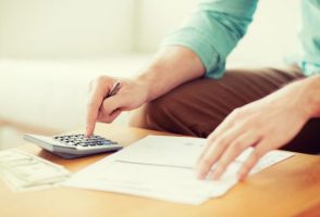 man-with-calculator-paperwork-and-cash