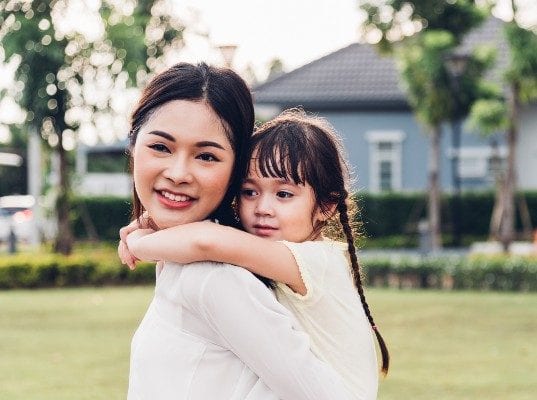 mom-giving-child-piggyback-ride-outside