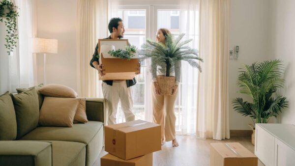 Couple moving boxes into a new home